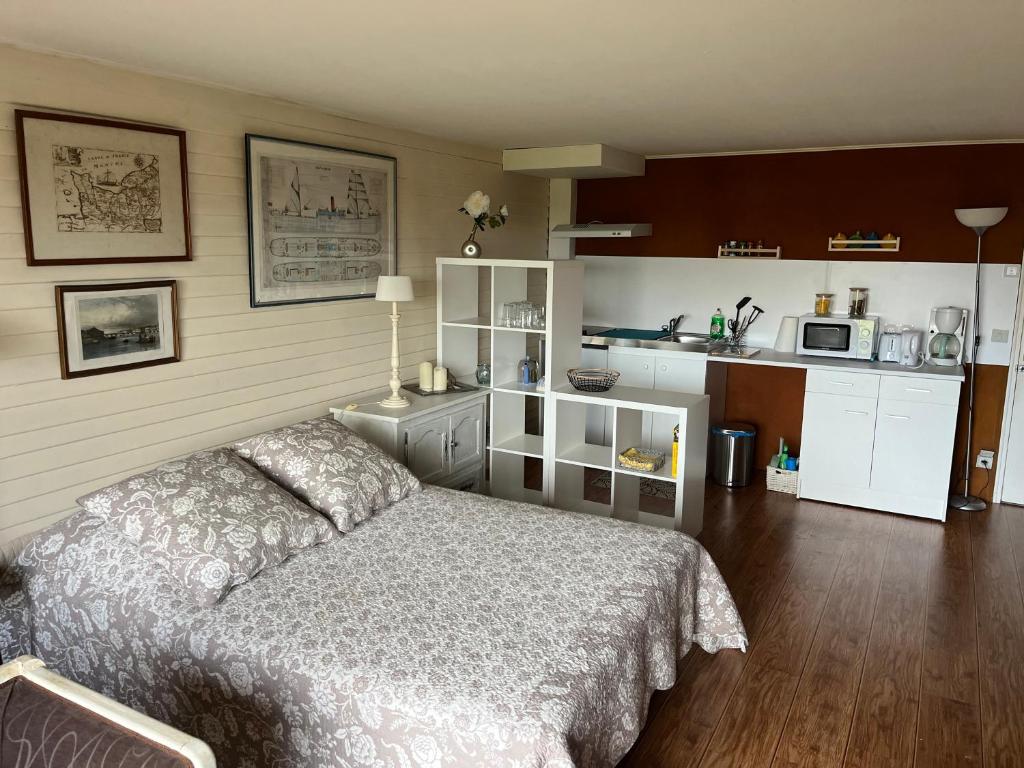 una camera con letto e cucina di Grand Studio Vue Mer et Jardin a Ver-sur-Mer