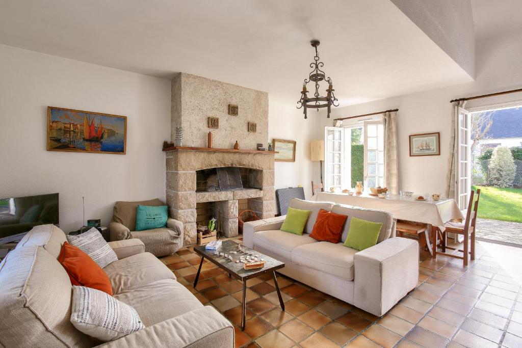a living room with two couches and a fireplace at Parenthèse familiale entre plages et golf in Pléneuf-Val-André