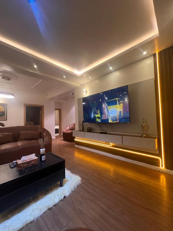 sala de estar con sofá y TV en Luxury 2 Bedroom Apartment in the Heart of WUSE 2, WIFI,NETFLIX, 24hrs Light en Abuja