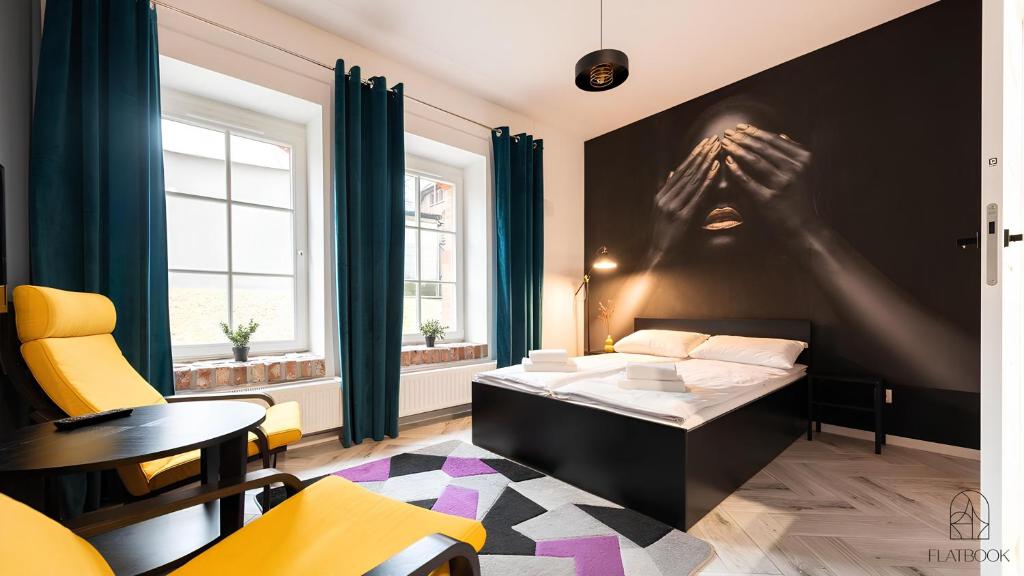 a hotel room with a bed and a persons hand on the wall at Flatbook - City Center Apartments Waterlane Vintage with Gym in Gdańsk