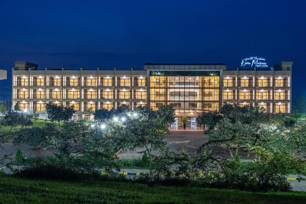 un gran edificio con luces encendidas por la noche en Mantis Kivu Marina Bay Hotel en Muhari