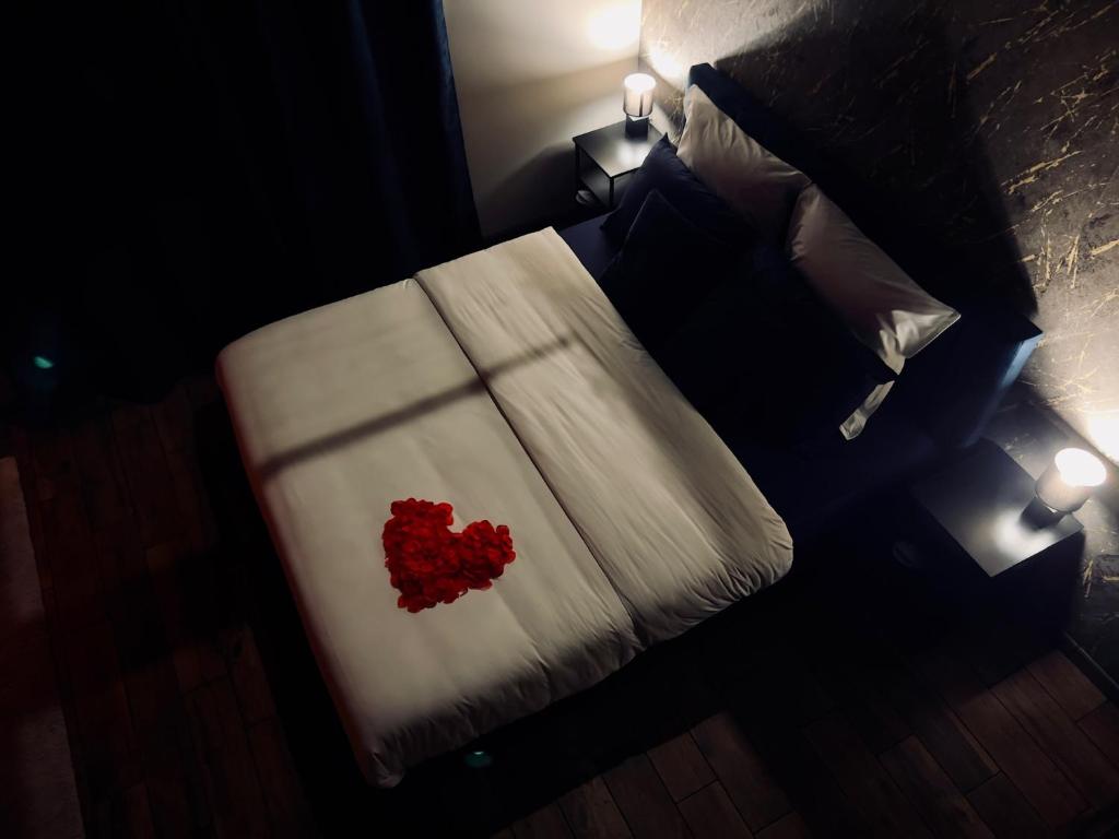 a bedroom with a bed with a red heart on it at Les secrets d&#39;Eros - DAX in Dax
