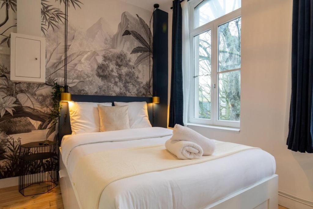 1 dormitorio con 1 cama blanca grande y ventana en Lille Center - Nice studio, en Lille