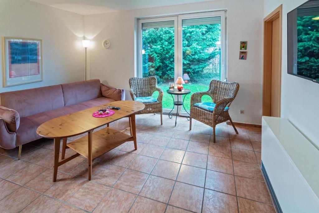 - un salon avec un canapé et une table dans l'établissement Ferienhaus Bettina, à Dornumersiel