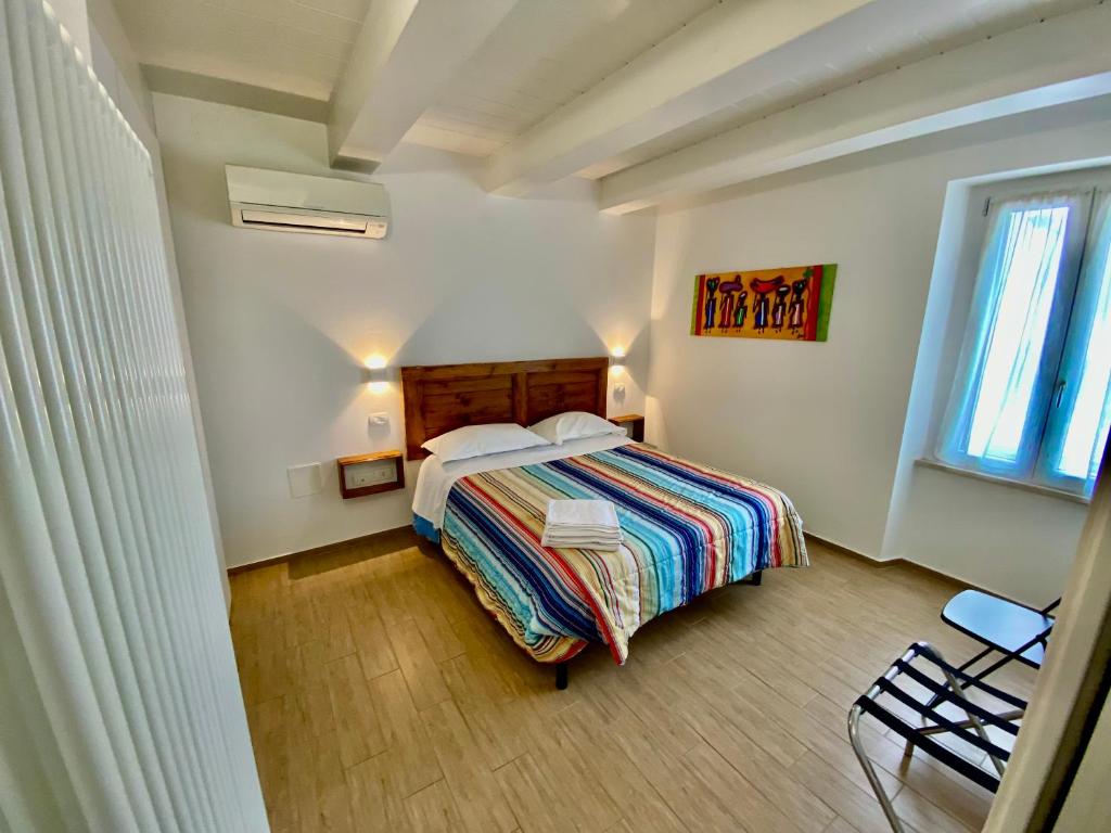 een slaapkamer met een bed, een raam en een stoel bij Appartamento vista mare! in Fano