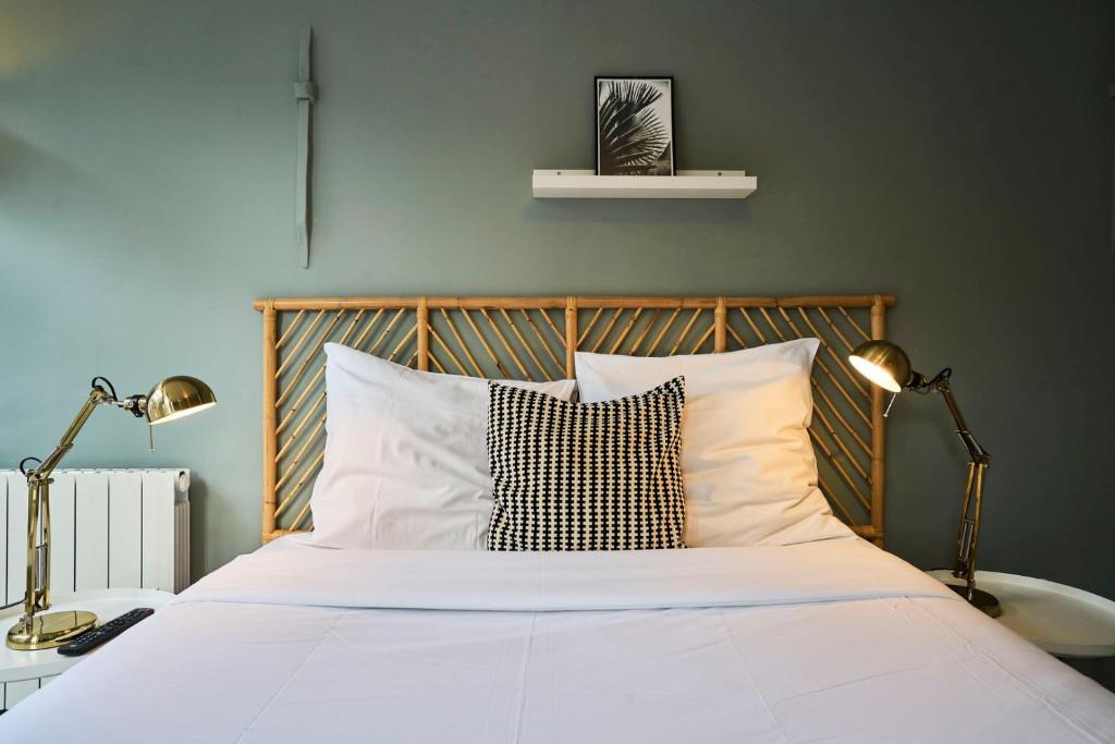 a bedroom with a white bed with two lamps at Lille Train station nice studio in Lille