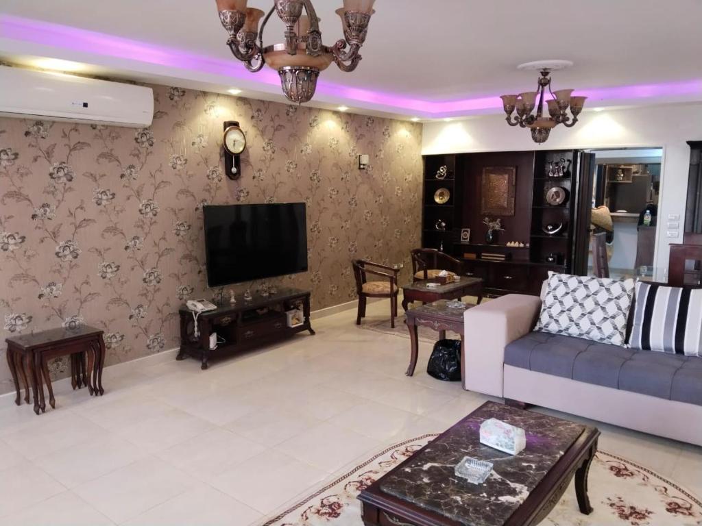 a living room with a couch and a tv at شقة راقية مطلة علي كورنيش النيل المعادي - عوائل فقط in Cairo