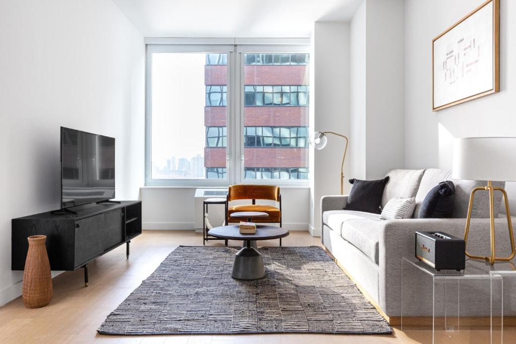 a living room with a couch and a tv at FiDi 1BR w Gym WD nr S St Seaport NYC-536 in New York