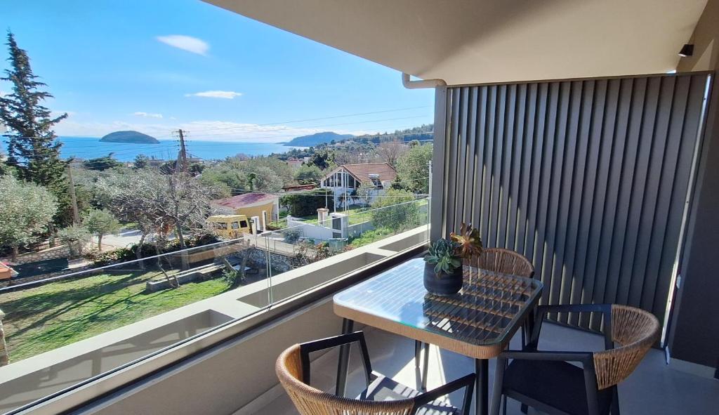 a balcony with a table and chairs and a view of the ocean at Welcome Inn in Paleo Tsifliki