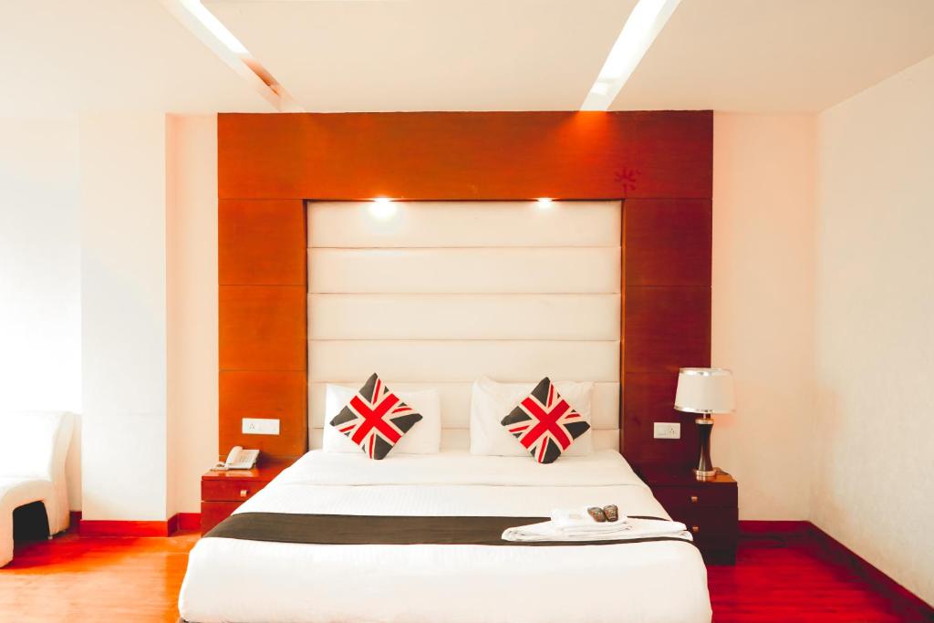 a bedroom with a large white bed with two pillows at Roomshala 152 Hotel Sukoon - Ramesh Nagar Metro Station in New Delhi