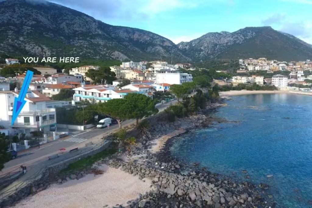 a view of a beach with a city and mountains at Nido Lungomare, e sei in spiaggia... in Cala Gonone
