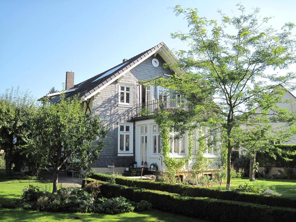 une maison blanche avec un toit noir dans l'établissement FeWo 110qm mit Balkon an Weser/Glacis/City, à Minden