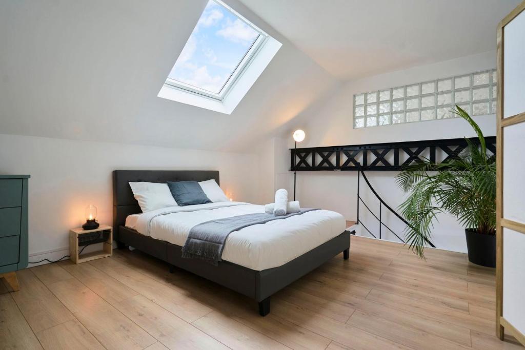 a bedroom with a bed and a skylight at Loft en duplex atypique 4ch + parking in Tourcoing