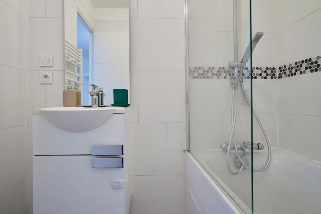 a white bathroom with a shower and a sink at Loft en duplex atypique 4ch + parking in Tourcoing
