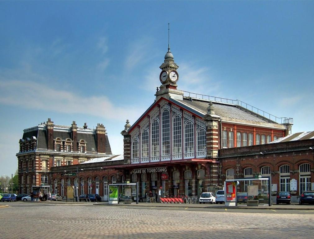 a building with a clock tower on top of it at Loft en duplex atypique 4ch + parking in Tourcoing