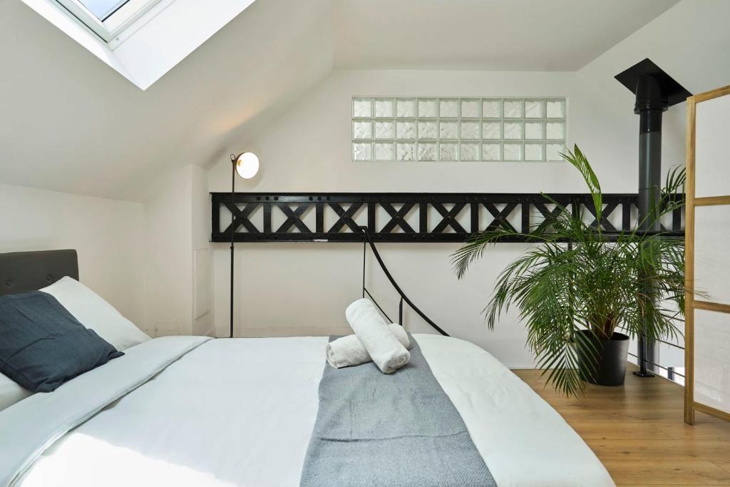 a bedroom with a large white bed and a skylight at Loft en duplex atypique 4ch + parking in Tourcoing