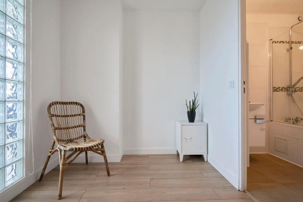 a chair in a room with a white wall at Loft en duplex atypique 4ch + parking in Tourcoing
