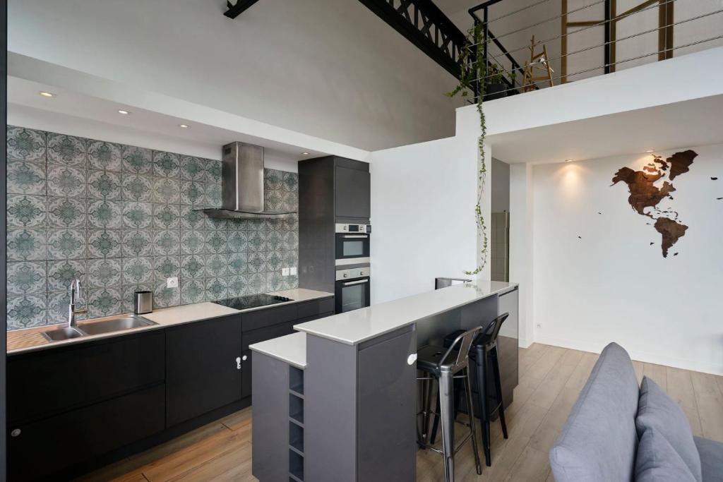 a kitchen with a sink and a counter top at Loft en duplex atypique 4ch + parking in Tourcoing