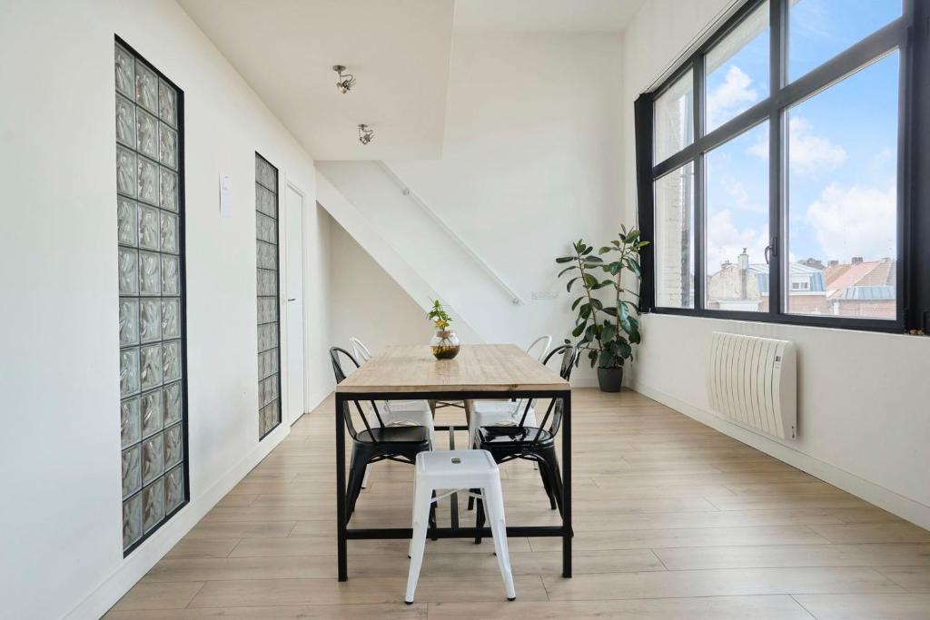 a dining room with a table and chairs at Loft en duplex atypique 4ch + parking in Tourcoing