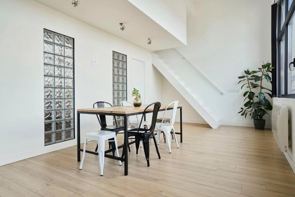 a dining room with a table and chairs at Loft en duplex atypique 4ch + parking in Tourcoing