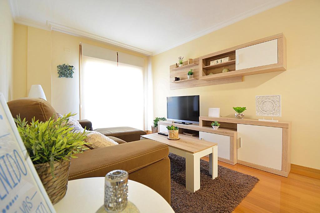 a living room with a couch and a tv at GALIHOST - Maravilloso apartamento en Combarro in Combarro