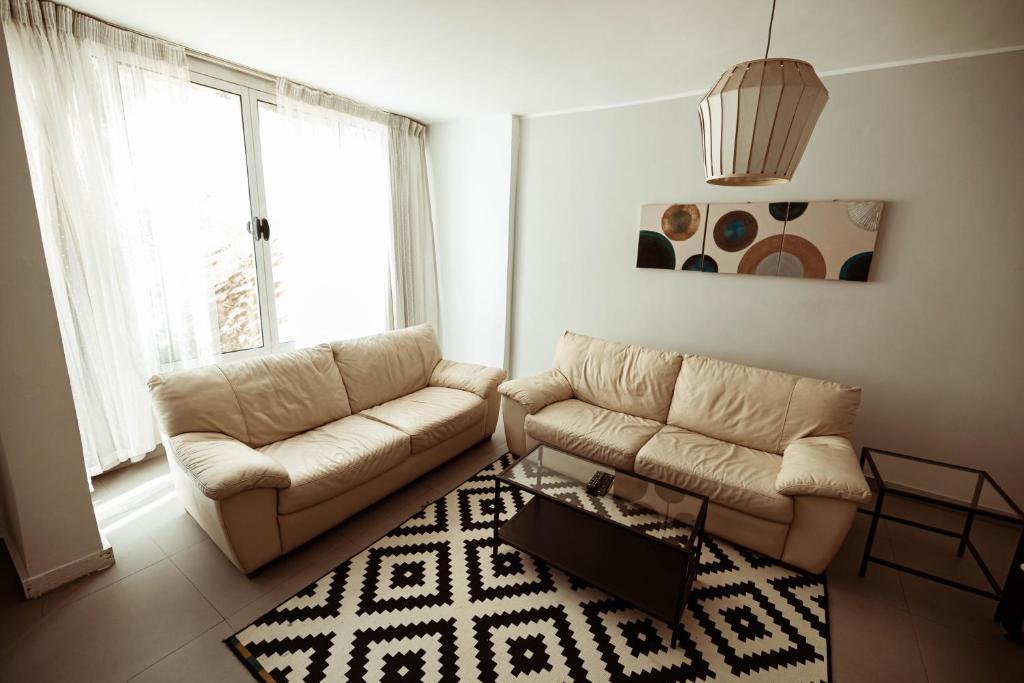 un soggiorno con 2 divani e un tappeto di Sage Bloom Retreat: 3BR Oasis Apartment a Il Cairo