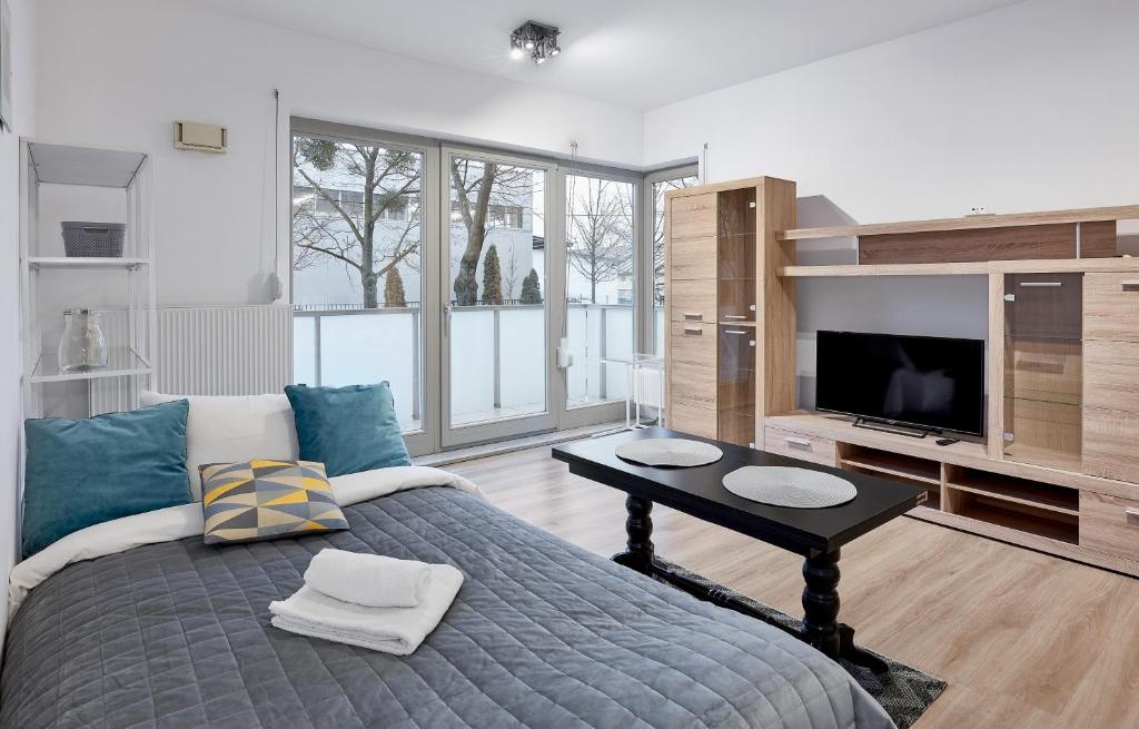 a bedroom with a bed with a table and a tv at Zawady Comfort Apartment in Poznań