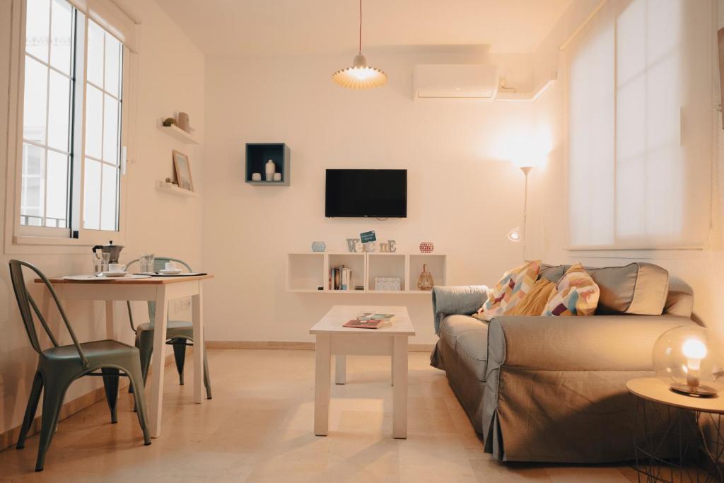 salon z kanapą i stołem w obiekcie Triana, cozy y con una ubicación ideal w Sewilli