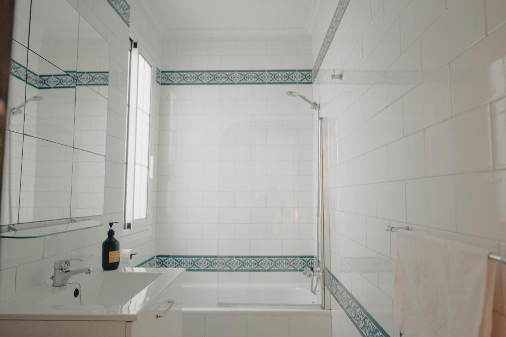 łazienka z wanną, umywalką i lustrem w obiekcie Triana, cozy y con una ubicación ideal w Sewilli