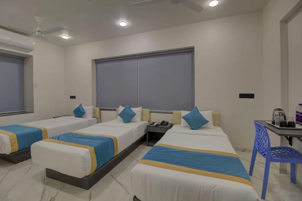 Habitación con 3 camas, mesa y escritorio. en 9 Bedroom Villa with Open Garden ALL ROOMS ATTACHED, en Pune