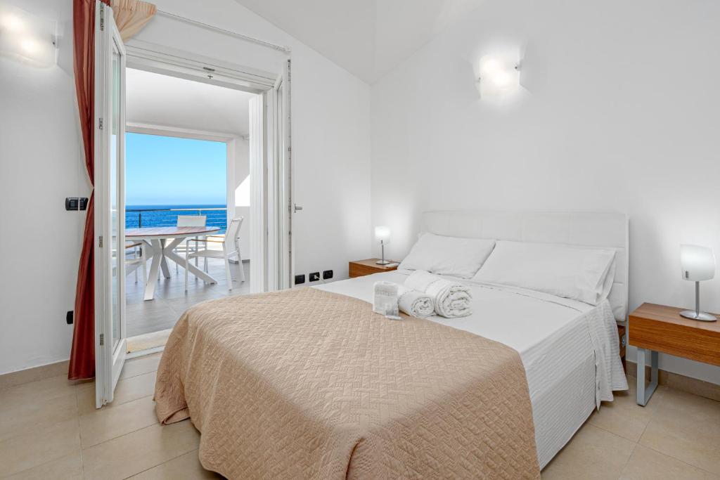 una camera con letto e vista sull'oceano di Villa Marconi Apartment 12a attico a Golfo Aranci