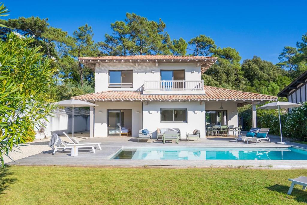 uma villa com uma piscina e uma casa em Pyla Belle villa au calme Proche plage em Pyla-sur-Mer