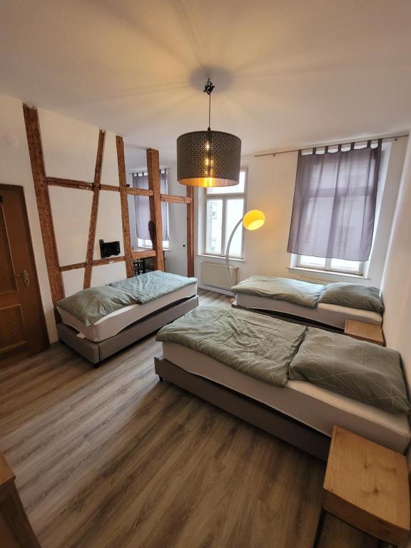 two beds in a room with wooden floors at Castle View Appartment in Nürnberg