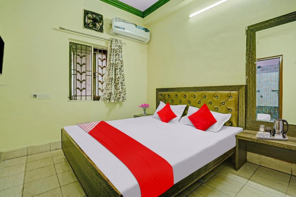 a bedroom with a large bed with red and white pillows at Flagship B N Palace in Raipur