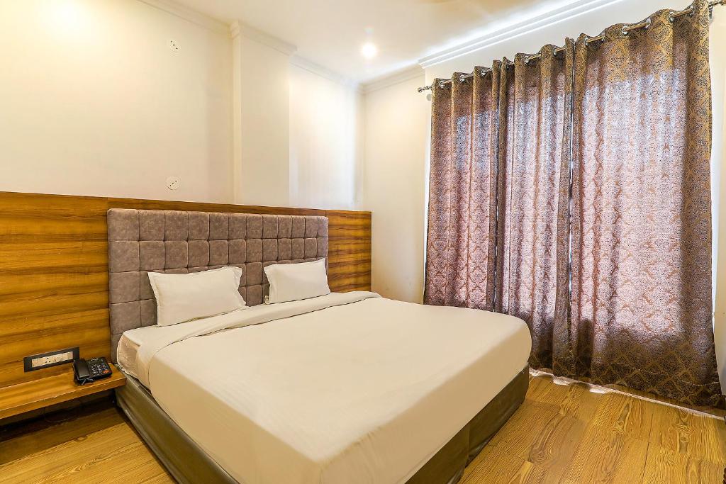 ein Schlafzimmer mit einem großen Bett und einem Fenster in der Unterkunft FabExpress Global Inn New in Lucknow