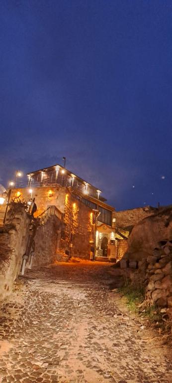 een stenen gebouw met 's nachts verlichting bij Sirius Cave Cappadocia in Urgup