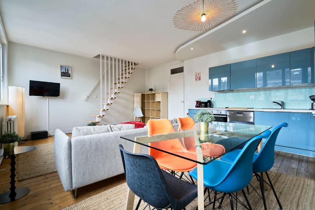 een keuken en een woonkamer met een glazen tafel en stoelen bij Lille hypercentre-2 bedrooms very bright + parking in Lille