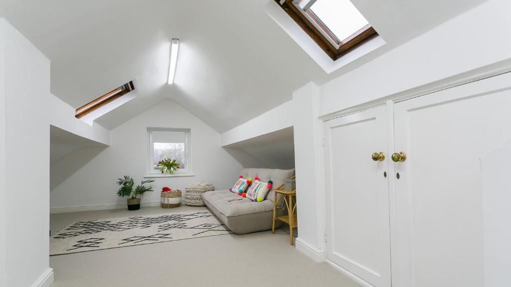 a living room with a couch and a vaulted ceiling at Ty Draw in Abersoch
