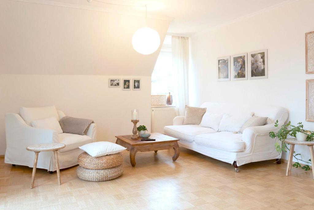 a living room with two white couches and a table at Ferienwohnung am Hafen Bad Bevensen in Bad Bevensen