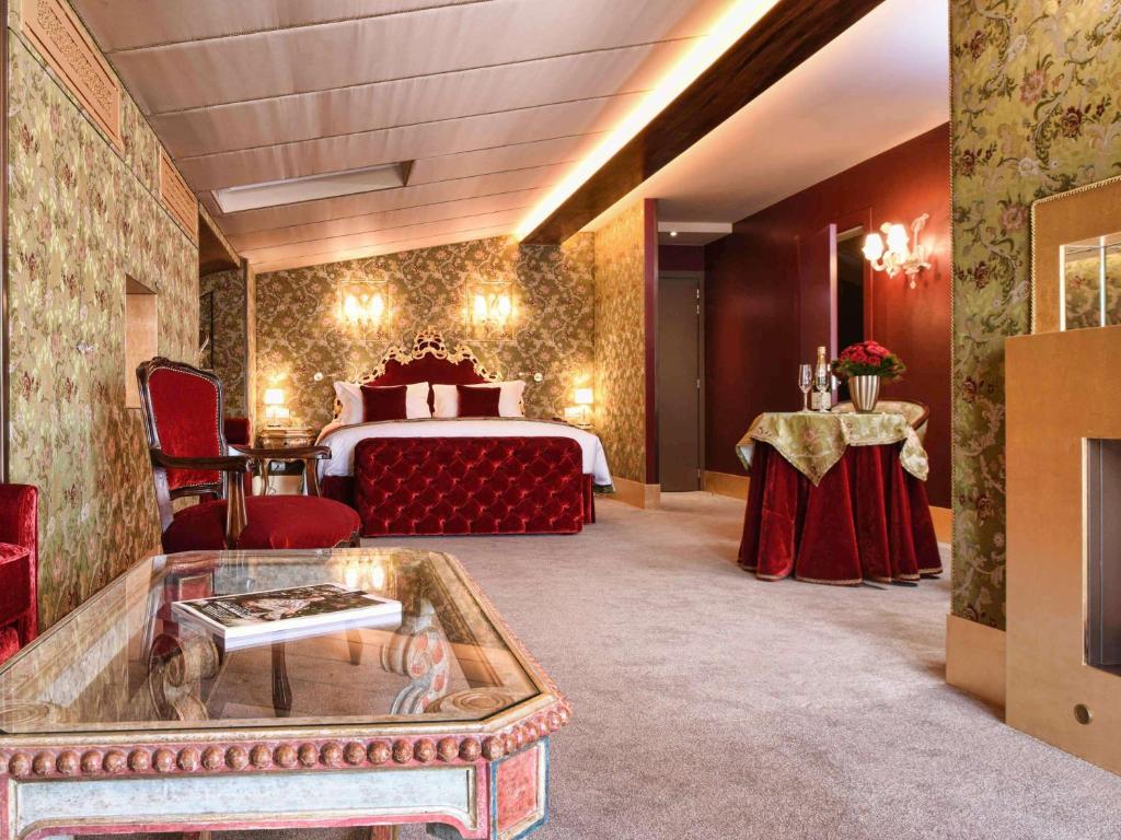 a hotel room with a bed and a table at Hotel Papadopoli Venezia - MGallery Collection in Venice