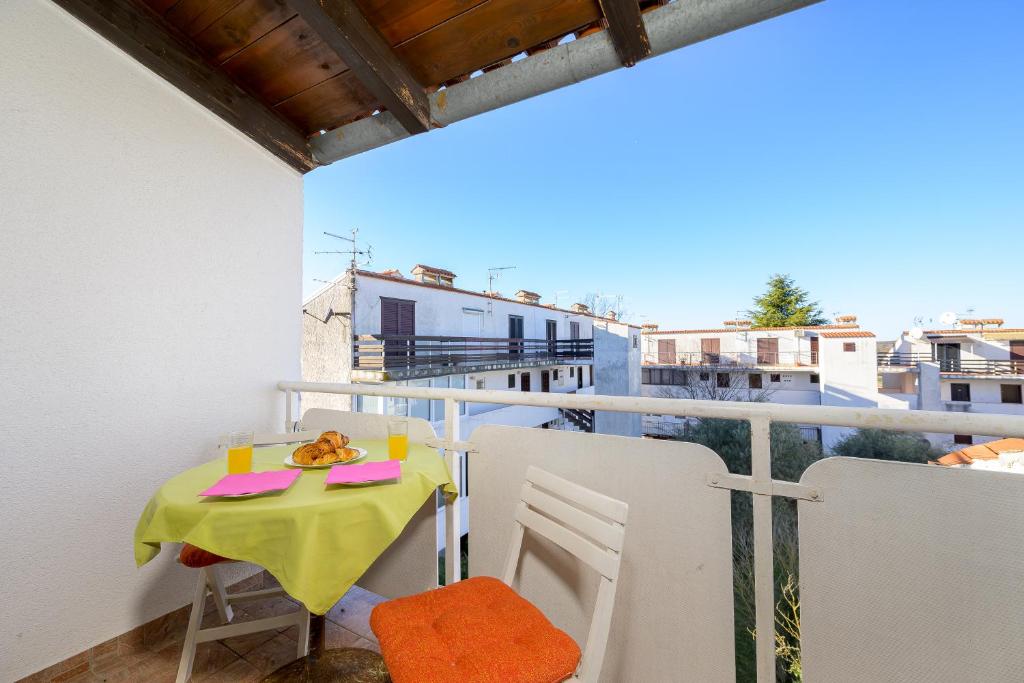 a table and chairs on a balcony with a view at Apartment Pinjola in Poreč