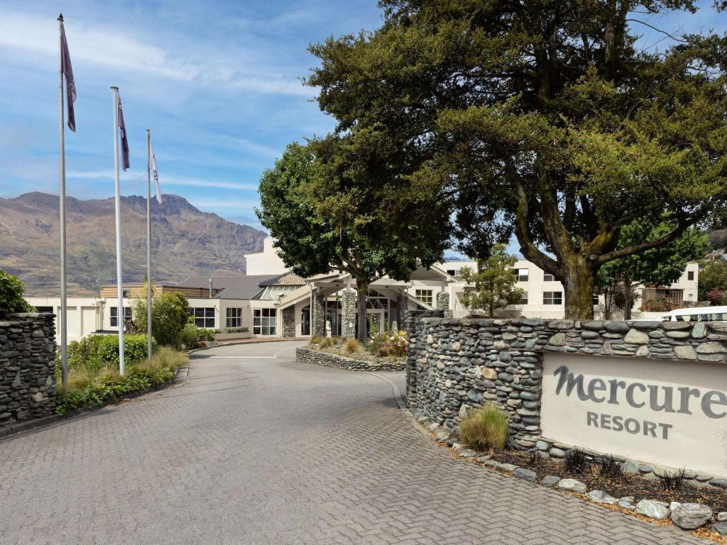 um sinal para um resort morongo em frente a um edifício em Mercure Queenstown Resort em Queenstown