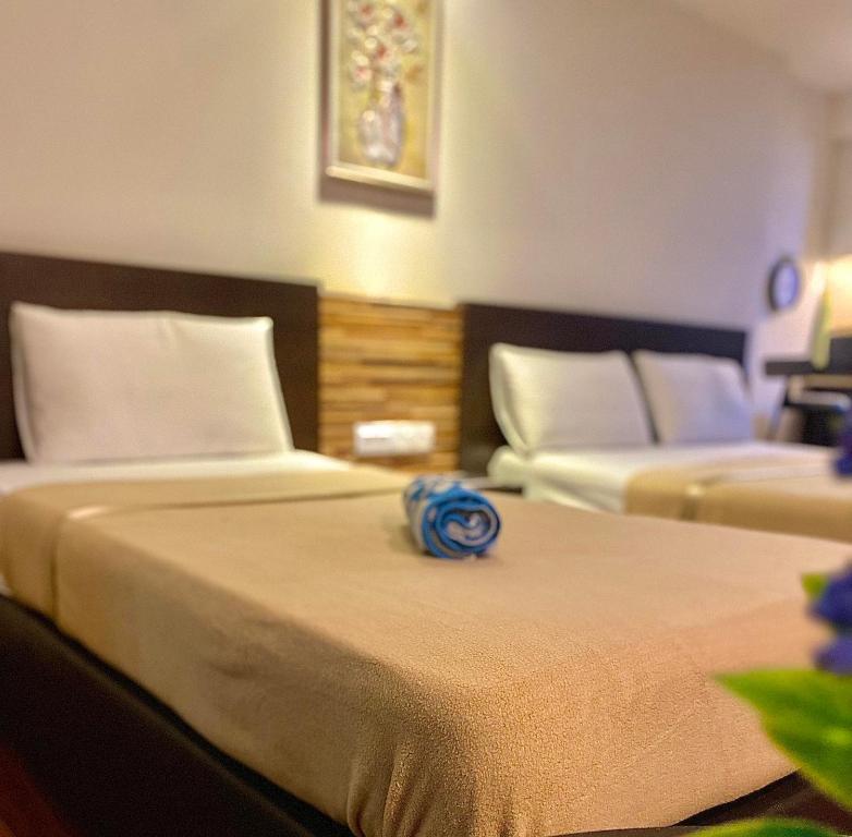Habitación de hotel con 2 camas con una flor azul en la parte superior en Ain Studio Apartment, en Kota Bharu
