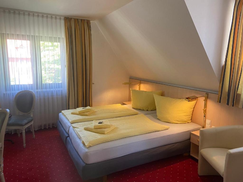 a bedroom with a bed with yellow sheets and yellow pillows at Gästehaus Niki in Tauberbischofsheim