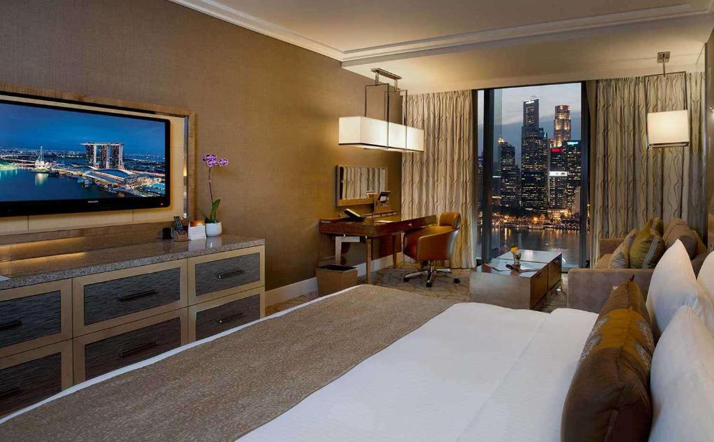 a hotel room with a bed and a large television at nour hotel in Dubai