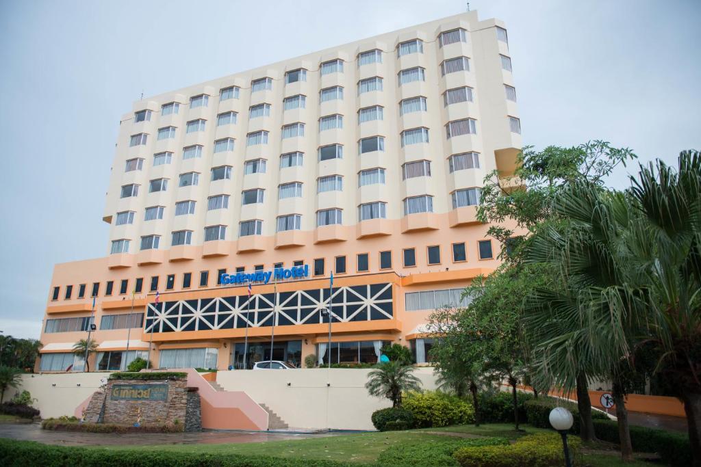 a large hotel building with trees in front of it at Phayao Gateway Hotel in Phayao