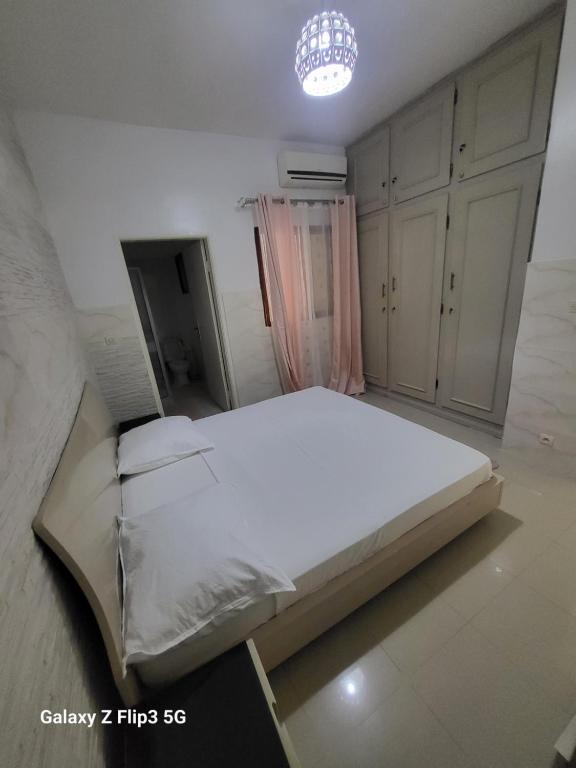 Ngor的住宿－Paradis Appartement，卧室配有一张白色大床