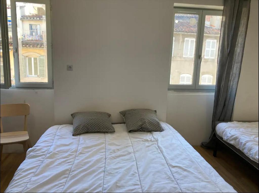 uma cama em um quarto com dois travesseiros em Studi 400 Vieux Port Opéra em Marselha