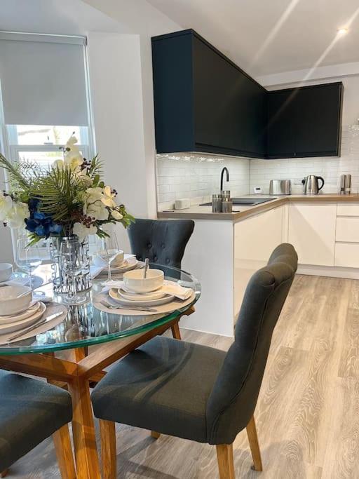 a kitchen with a glass table with chairs and a tableasteryasteryasteryasteryastery at Luxury 3 Bedroom House in Worthing