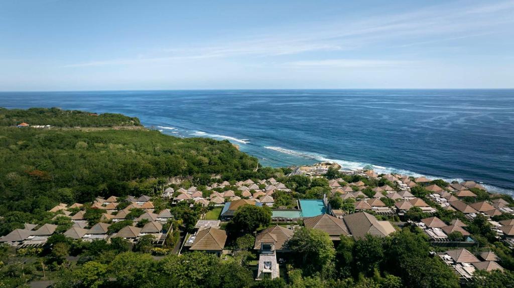 Umana Bali, LXR Hotels & Resorts في أُلُواتو: اطلالة جوية على حي سكني بجوار المحيط